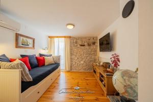 a living room with a couch and a stone wall at Charming old stone house in Sali