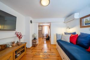 a living room with a blue couch and a tv at Charming old stone house in Sali