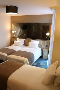 a hotel room with three beds in a room at Le Saint Aubert in Le Mont Saint Michel +20 photos