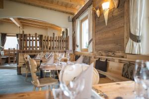 a restaurant with wooden walls and tables and chairs at Rifugio La Para in San Vigilio Di Marebbe