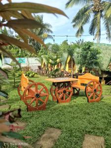 a picnic table and benches in the grass at Itawis Resort - Balai Angel in Silang +10 photos