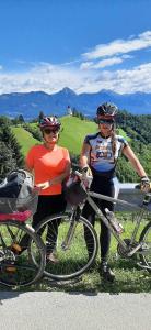 two women standing with their bikes on the side of a road at Camp Starshine near Bled in Begunje na Gorenjskem
