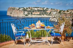 a table with food on a balcony overlooking the ocean at Las Escaleras - Villa PEKA - 4S in Port d’Andratx