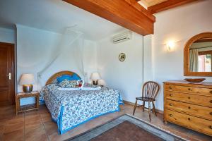 a bedroom with a bed and a chair and a dresser at Las Escaleras - Villa PEKA - 4S in Port d’Andratx