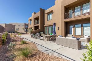 a home with a patio with chairs and a table at Poolside Escape At The Ledges in St. George