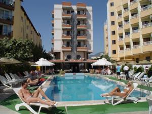 a group of people sitting in chairs by a swimming pool at Aegean Park Hotel in Marmaris