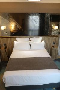 a hotel room with a bed and two lamps at Le Saint Aubert in Le Mont Saint Michel