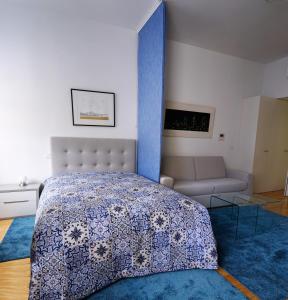 a bedroom with a bed and a couch at Home At Porto - Aliados Apartments in Porto