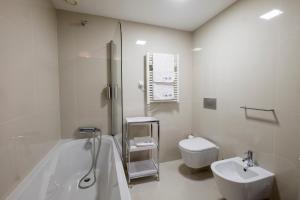 een badkamer met een bad, een toilet en een wastafel bij Home At Porto - Aliados Apartments in Porto