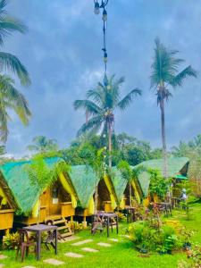 a resort with tables and palm trees in front of it at Itawis Resort - Balai Angel in Silang
