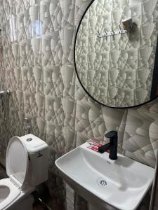 a bathroom with a sink and a mirror on the wall at Gekamo Suites in Dar es Salaam