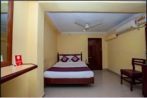 a bedroom with a bed and a table and a chair at JPResidency in Pondicherry