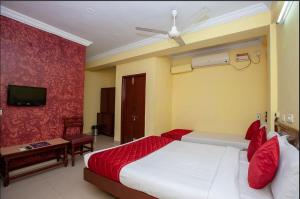 a hotel room with a bed and a tv at JPResidency in Pondicherry