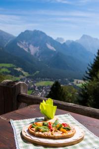 uma pizza numa mesa com vista para as montanhas em Rifugio La Para em San Vigilio Di Marebbe
