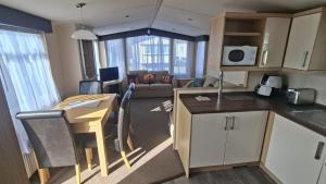 a kitchen and living room with a table and a kitchen and a living room at Oystercatcher Hide, Chruch Farm in Pagham