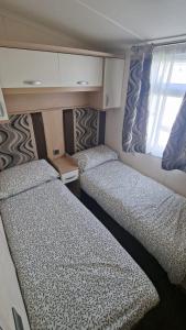 two beds in a small room on a boat at Oystercatcher Hide, Chruch Farm in Pagham +2 photos