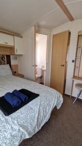 a bedroom with a bed with blue towels on it at Oystercatcher Hide, Chruch Farm in Pagham