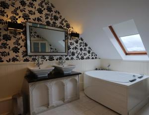 a bathroom with a tub and two sinks and a mirror at Ballagh House in Navan +11 photos