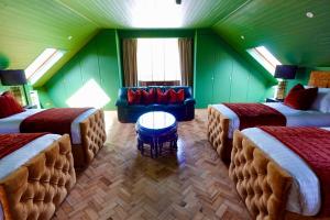 a room with three beds and a couch in it at Ballagh House in Navan