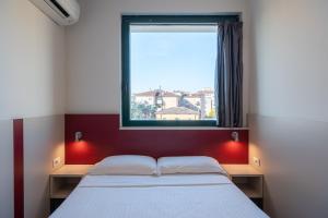 a bedroom with a bed and a window at Hotel Porta Palio in Verona