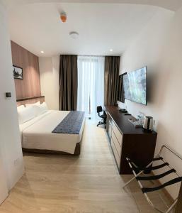 a hotel room with a bed and a desk at Sri Gaya Hotel in Kota Kinabalu