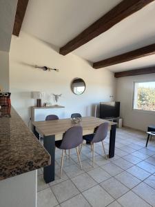 a kitchen with a table and chairs in a room at Mini Villa avec piscine privée in Porto-Vecchio