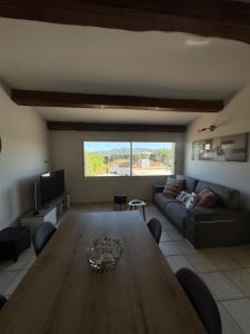a living room with a wooden table and a couch at Mini Villa avec piscine privée in Porto-Vecchio
