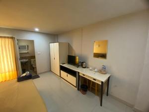 a small room with a desk and a refrigerator at Ladapan Mansion in Nonthaburi