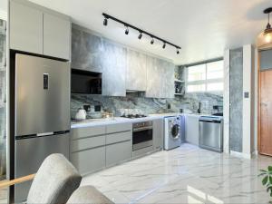 a kitchen with stainless steel appliances and a washer and dryer at Sea Esta On Beach in Strand