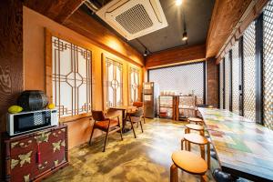 a room with a long table and chairs and windows at Ddlanchae Guesthouse - New Tower in Jeonju