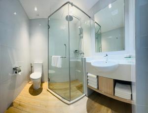 a bathroom with a glass shower and a sink at Sri Gaya Hotel in Kota Kinabalu