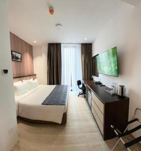 a hotel room with a bed and a flat screen tv at Sri Gaya Hotel in Kota Kinabalu