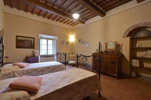 a bedroom with two beds and a dresser in it at Il Maggese in Cortona