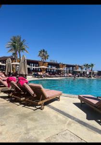 a group of lounge chairs and umbrellas next to a swimming pool at Grand Saphire Resort c blok in Aradhippou
