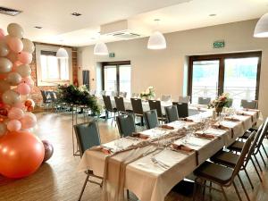 a banquet hall with long tables and chairs and balloons at Hotel Port 110 in Iława