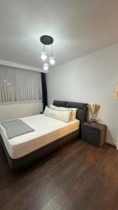 a bedroom with a large bed and a night stand at Grand Saphire Resort c blok in Aradhippou