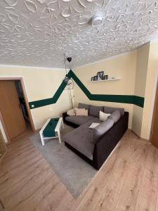 a living room with a couch and a green stripe on the ceiling at Ferienwohnung Waldblick in Brilon