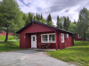 a red shed with a porch and a table at Tärnaby Sportstugor in Tärnaby