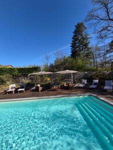 a swimming pool with some chairs at Le chalet du Cerf - Chambre d'hôte in Somme-Leuze
