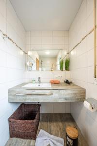 a bathroom with a sink and a mirror at Das Ferienhaus Oberstdorf in Oberstdorf +30 photos