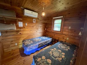 a room with two beds in a log cabin at Family Cottage Pokhara in Yamanakako