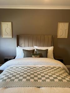 a bedroom with a bed with a checkered blanket at Waterside House in Kilbarchan