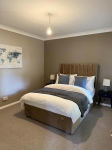 a bedroom with a large bed with blue pillows at Waterside House in Kilbarchan