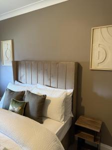 a bedroom with a bed with a wooden headboard at Waterside House in Kilbarchan