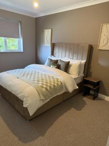 a bedroom with a large bed and a window at Waterside House in Kilbarchan