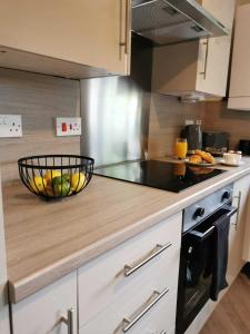 a kitchen with a bowl of fruit on a counter at Limekilns House in Clydebank