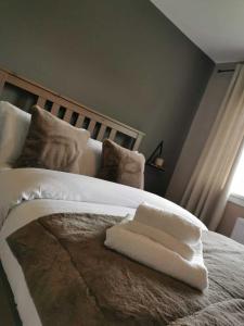 a white towel sitting on top of a bed at Limekilns House in Clydebank
