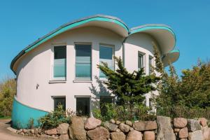an orb shaped house with a stone wall at Muschel 2 in Ahrenshoop
