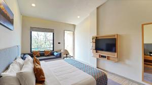 a hotel room with a bed and a tv at Palette Hotel Orient Greenz by CheckIn, Pench in Khawāsa
