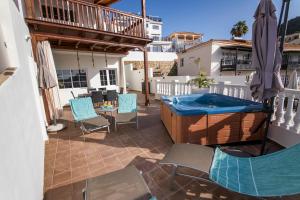 a patio with a hot tub and a table and chairs at Sea Breeze Arguineguin in Mogán